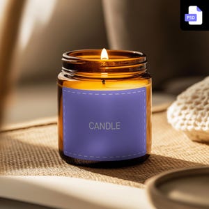 May include: A brown glass candle jar with a purple label that says "CANDLE". The candle is lit and the flame is visible.