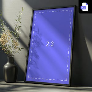 Può includere: Un mockup di poster incorniciato in nero con uno sfondo blu e il testo "2:3" in bianco. Il poster è appoggiato contro un muro grigio.