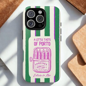 K&ouml;nnte beinhalten: Handyh&uuml;lle mit gr&uuml;n-wei&szlig;em Streifenmuster. Sie zeigt eine Grafik einer Sardinenb&uuml;chse mit dem Text "A Little Taste of Porto" und "Sardines Wild Caught in Olive Oil".