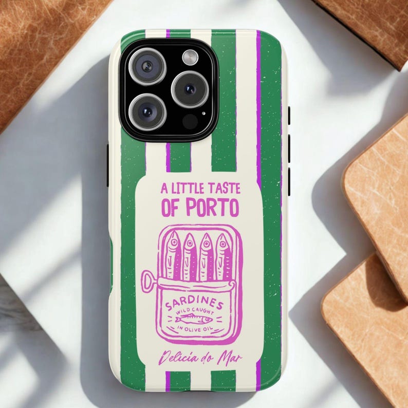 K&ouml;nnte beinhalten: Handyh&uuml;lle mit gr&uuml;n-wei&szlig;em Streifenmuster. Sie zeigt eine Grafik einer Sardinenb&uuml;chse mit dem Text "A Little Taste of Porto" und "Sardines Wild Caught in Olive Oil".