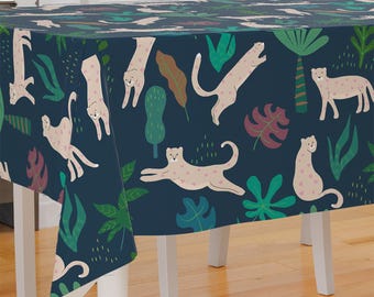 May include: A navy blue tablecloth with a repeating pattern of pink leopards and green tropical leaves.