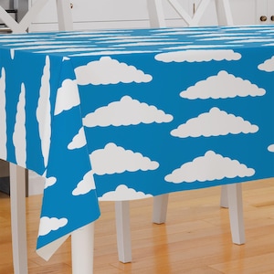May include: A blue tablecloth with a white cloud pattern. The tablecloth is rectangular and has a white border.