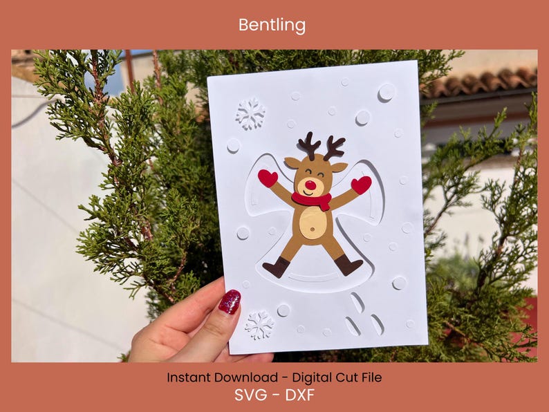 May include: A white card featuring a reindeer making a snow angel, with a red scarf and mittens. The card has a snowflake design and the text "Bentling" at the top. The bottom of the card reads "Instant Download - Digital Cut File SVG - DXF".