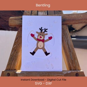 May include: A white card featuring a reindeer making a snow angel, with red mittens and scarf. The card has embossed snowflakes and is displayed on a wooden structure. Text at the top reads "Bentling".