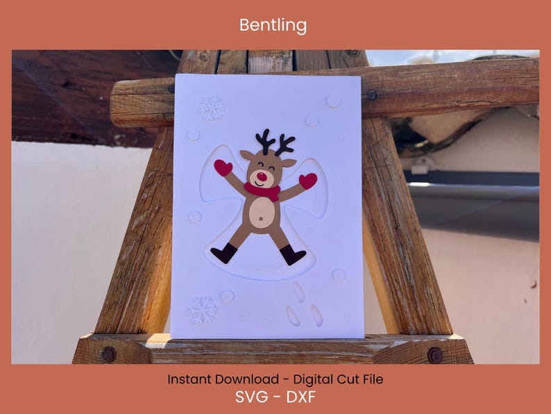 May include: A white card featuring a reindeer making a snow angel, with red mittens and scarf. The card has embossed snowflakes and is displayed on a wooden structure. Text at the top reads "Bentling".