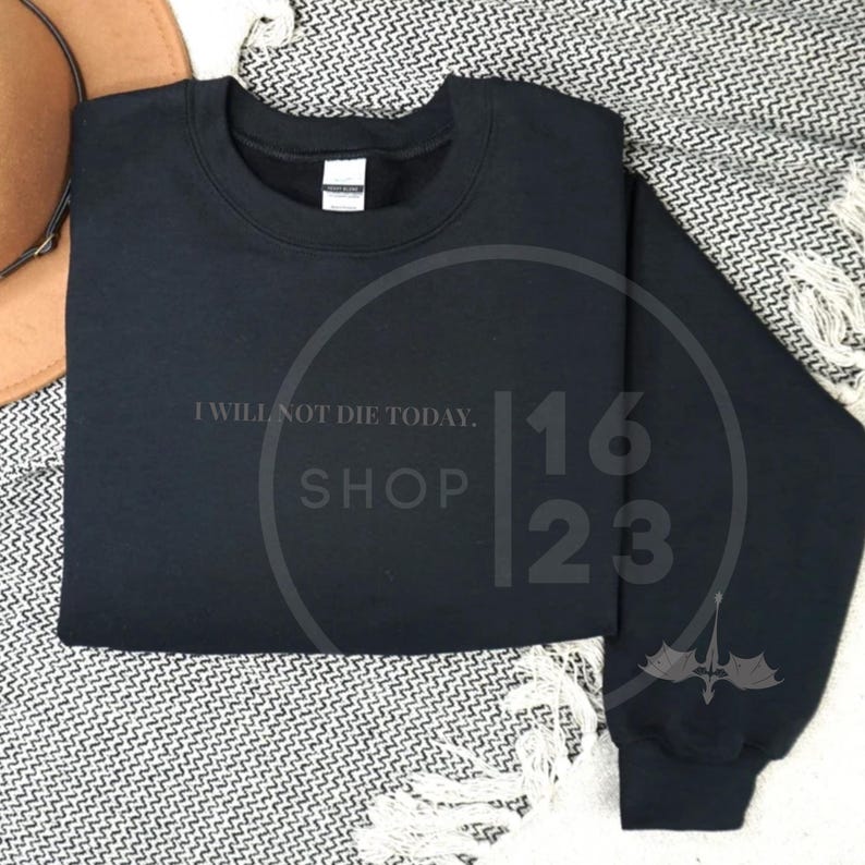 May include: Black sweatshirt with the text "I will not die today. Shop 1623" printed on the front.