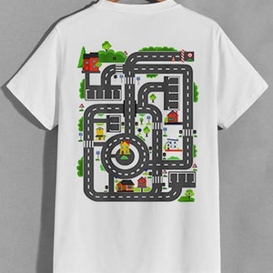 お父さんの背中にカーレーストラックが付いたプレイマットTシャツ。背中にカーレースが付いたプレイマット。カーレースTシャツ。トレンディな父の日ギフト、プレゼント、ユニセックス、メンズ、レディース、トップス。