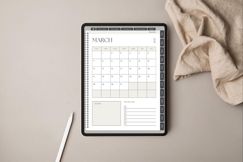 May include: A digital tablet displaying a March 2027 monthly calendar planner page with a spiral binding graphic, a notes section, and a to-do list. The interface includes side tabs for navigation and a white stylus is positioned near the tablet.