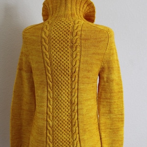 May include: A yellow knitted sweater with a high collar and cable knit detail on the back.
