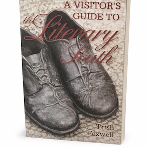 May include: A book titled "A Visitor's Guide to the Literary South" by Trish Foxwell. The cover features a sepia-toned image of a pair of worn leather shoes. The title is in a cursive font, with the word "Literary" in a larger font.