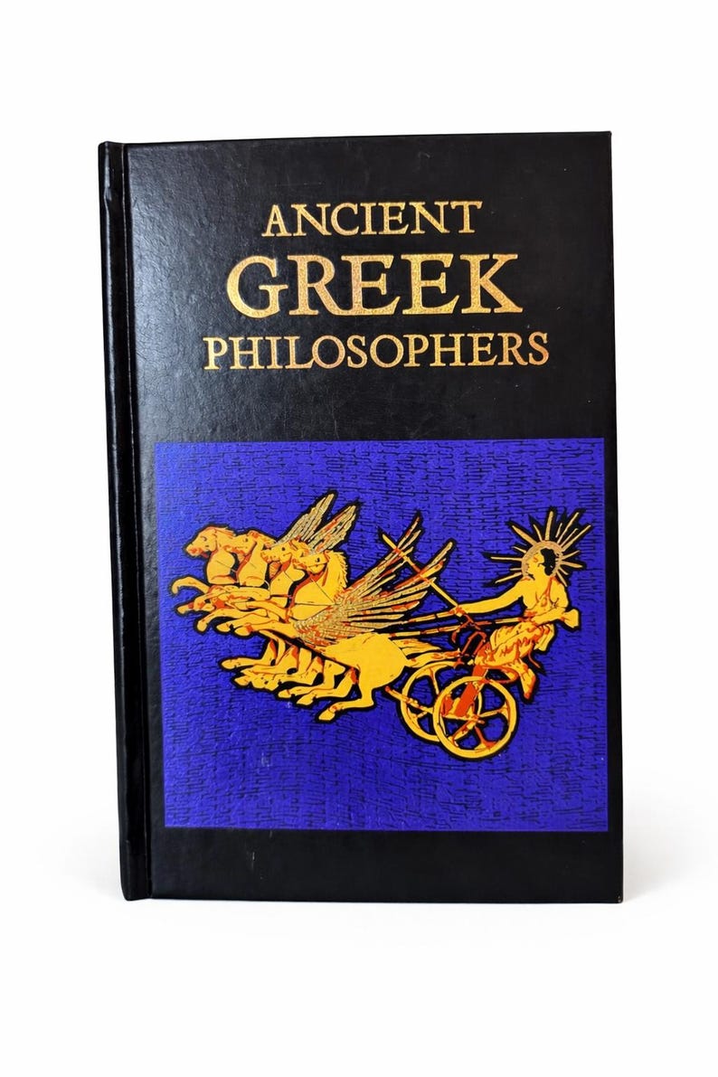 May include: A hardcover book titled "ANCIENT GREEK PHILOSOPHERS" in gold lettering on a black cover. The book features a blue panel with a gold illustration of a chariot pulled by winged horses.