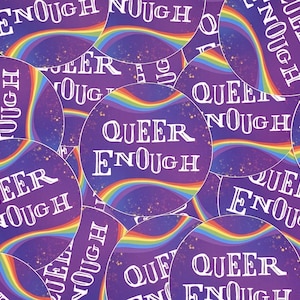 Peut inclure: Gros plan sur plusieurs autocollants ronds avec un motif arc-en-ciel et le texte "Queer Enough" en lettres blanches sur un fond violet.