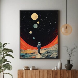 以下が含まれることがあります： 白い宇宙服を着た宇宙飛行士が、赤とオレンジの惑星を歩いているデジタルアートプリント。暗い星空と、背景に複数の白い惑星がある。
