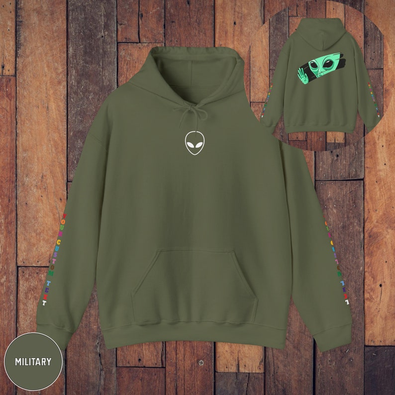 Peut inclure: Un sweat &agrave; capuche vert militaire avec un graphique d'extraterrestre blanc sur le devant et du texte color&eacute; sur les manches. Le texte dit "YOU ARE CUSTOM TEXT".