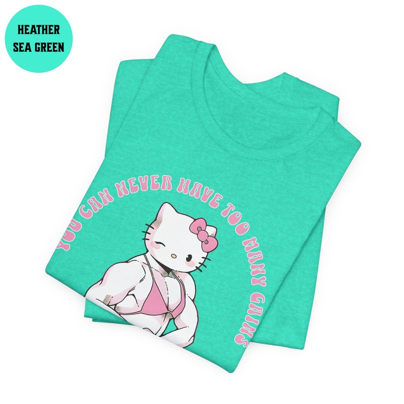 May include: A heather sea green t-shirt with a pink graphic of Hello Kitty with muscles and the text "You can never have too many gains".