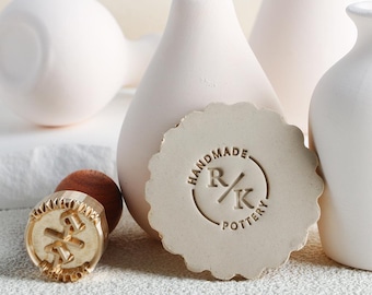 May include: A collection of handmade pottery items. The image features a light beige stamp with the text "HANDMADE R/K POTTERY" and a gold-colored stamp. Several white ceramic vases are in the background.