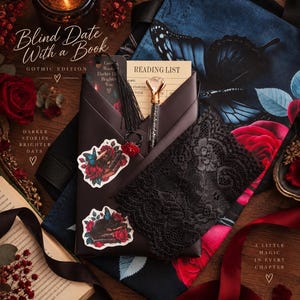 May include: A Blind Date With a Book Gothic Edition set featuring a black envelope containing a reading list, a crystal-topped pen, a black tassel bookmark, and two stickers with rose and butterfly illustrations, all resting on a floral fabric.