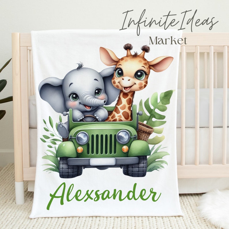 Puede incluir: Una manta de beb&eacute; blanca con un jeep verde, un elefante y una jirafa. El jeep tiene una cesta verde en el lateral. El elefante conduce el jeep y la jirafa est&aacute; sentada en el asiento del pasajero. La manta tiene el nombre "Alexander" escrito en letras verdes en la parte inferior.