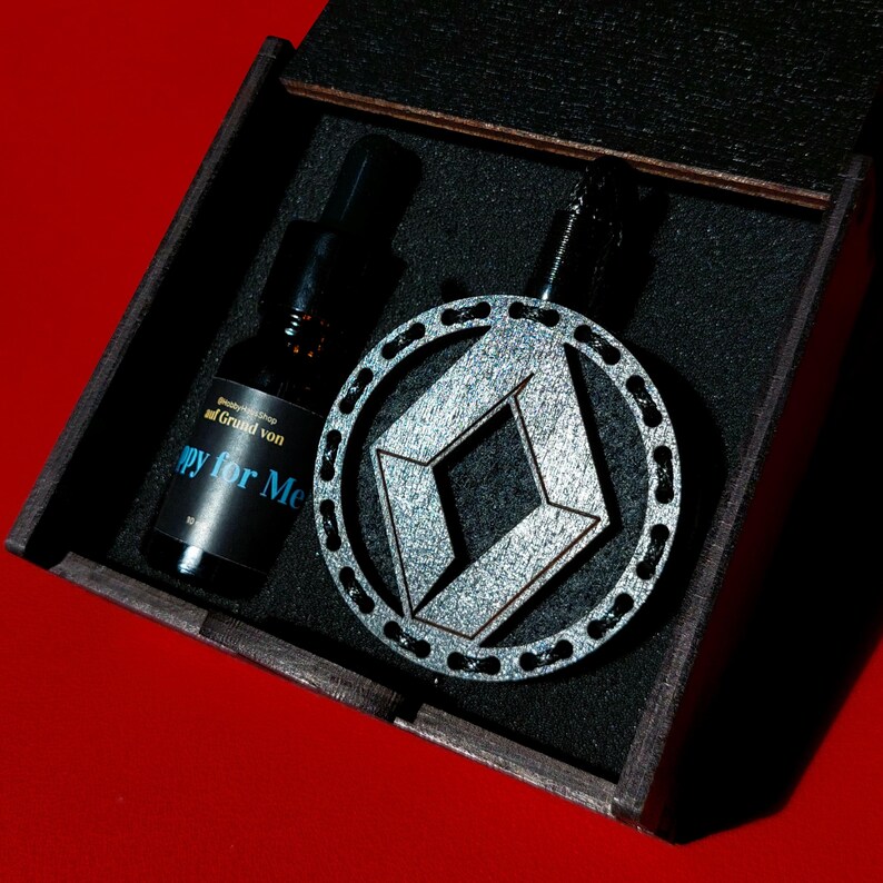 May include: A black wooden box with a silver and black geometric design pendant and a small bottle with a black label that says "Grand von" and "Happy for Me".