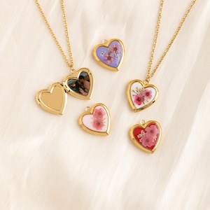 May include: Five gold heart-shaped lockets with different floral and photo designs. The lockets are on a white background.