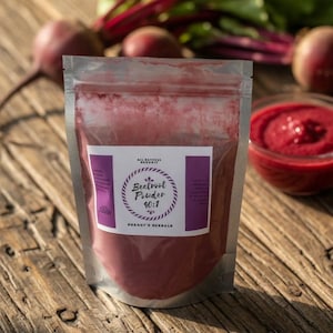 May include: A clear, silver pouch of beetroot powder with a purple label, a small glass bowl of beetroot puree, and fresh beets with green leaves on a wooden surface. The label reads "Beetroot Powder 40:1" and "Shagg's Herbals."