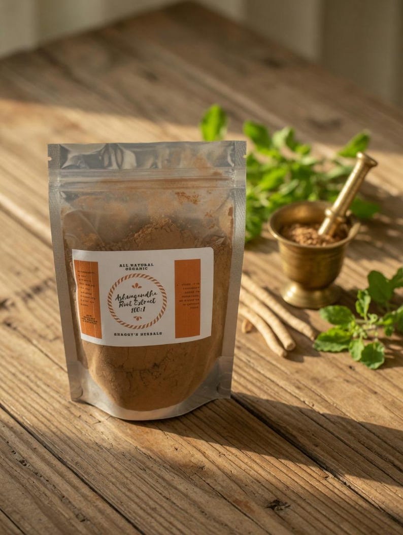 May include: A clear, resealable pouch filled with brown powder, labeled "Ashwagandha Root Extract 100:1" and "Shagott's Herbals." A small brass mortar and pestle, along with fresh green herbs and dried roots, sit on a wooden surface.