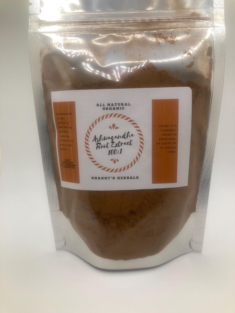 May include: A clear, resealable pouch filled with brown powder. The pouch has a white label with the text "ALL NATURAL ORGANIC" and "Ashwagandha Root Extract 100:1". The brand name "SHAGGY'S HERBALS" is also visible.