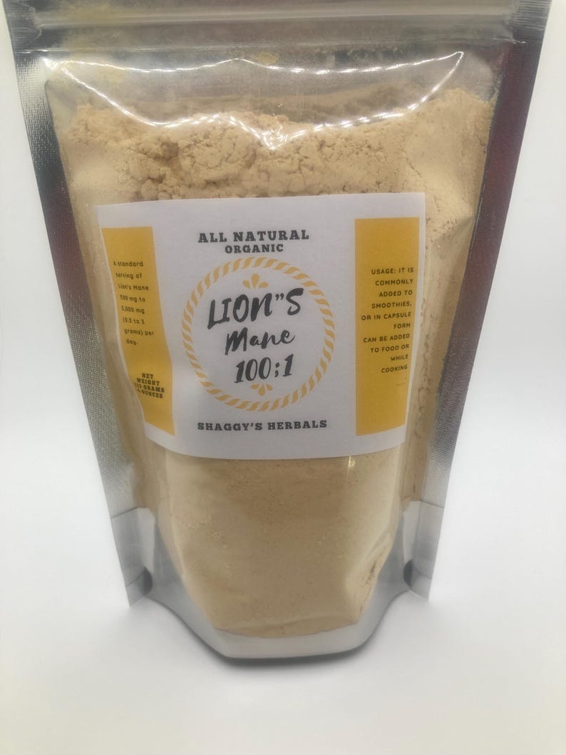 May include: A clear, sealed bag filled with light brown powder. The bag has a white and yellow label with the text "ALL NATURAL ORGANIC" and "LION'S Mane 100:1". The label also includes usage instructions and the brand name "SHAGGY'S HERBALS".