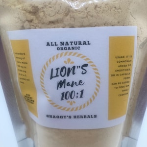 May include: A clear plastic bag filled with a light brown powder. The bag has a white label with the text "ALL NATURAL ORGANIC" and "LION'S Mane 100:1". The label also includes the text "SHAGGY'S HERBALS".