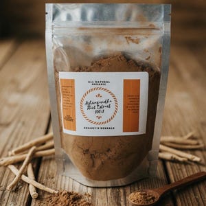May include: A clear, resealable pouch filled with brown powder, labeled "Ashwagandha Root Extract 100:1" from Shaggy's Herbals. A wooden spoon holds a small amount of the powder. Ashwagandha roots are scattered on the wooden surface.