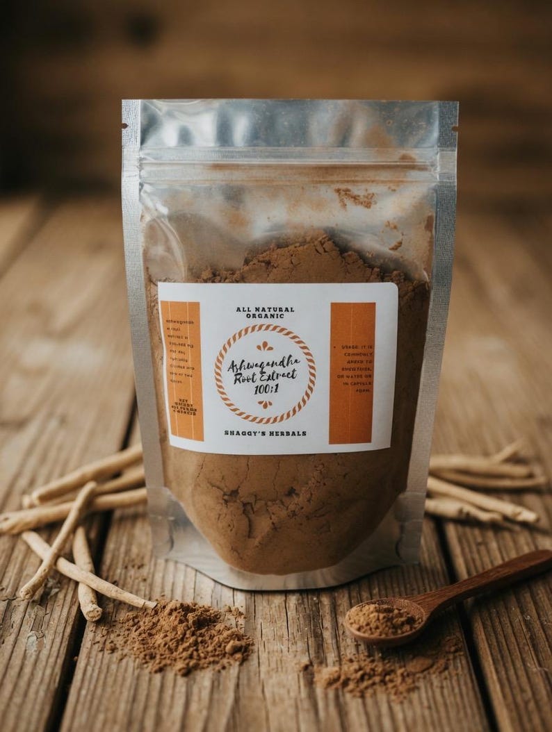 May include: A clear, resealable pouch filled with brown powder, labeled "Ashwagandha Root Extract 100:1" from Shaggy's Herbals. A wooden spoon holds a small amount of the powder. Ashwagandha roots are scattered on the wooden surface.