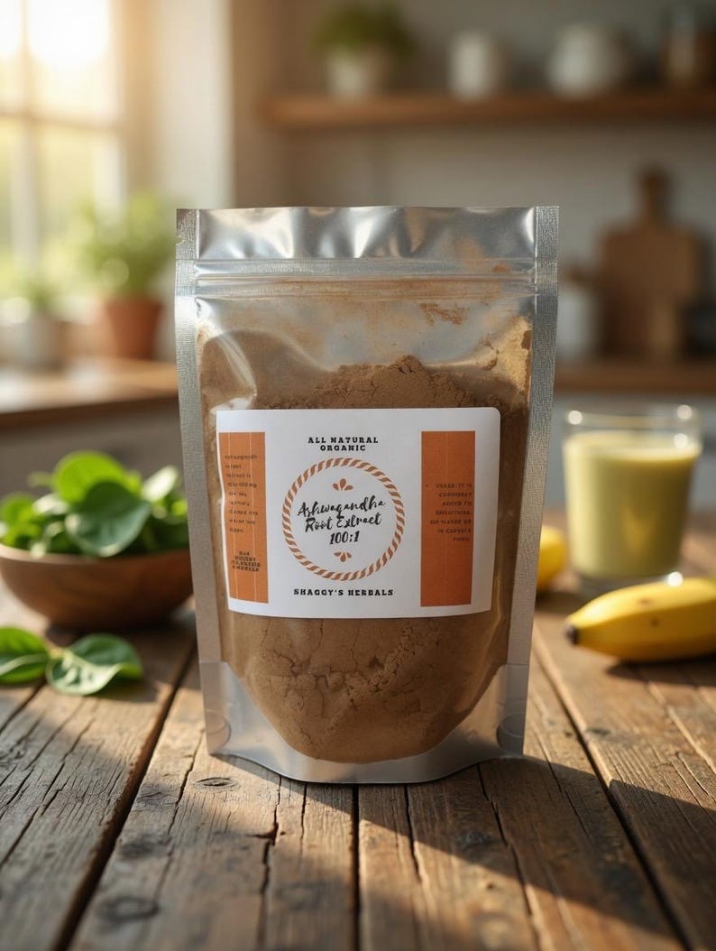 May include: A clear, resealable pouch filled with brown powder, labeled "Ashwagandha Root Extract 100:1" and "Shaggy's Herbals." The pouch sits on a rustic wooden table, with a bowl of greens and a smoothie in the background. The words "All Natural Organic" are also on the label.