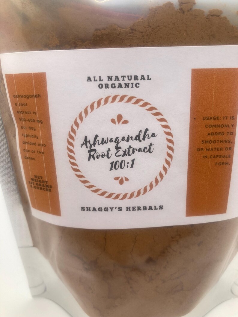 May include: A clear plastic bag filled with brown powder. The label reads "Ashwagandha Root Extract 100:1" with "All Natural Organic" above and "Shaggy's Herbals" below. The net weight is 113 grams or 4 ounces.