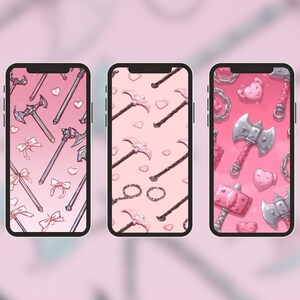 Pode incluir: Três smartphones exibindo designs de papel de parede rosa. Os designs apresentam ilustrações de armas, laços, corações e anéis. Os telefones estão em um fundo rosa suave, criando uma estética coesa.