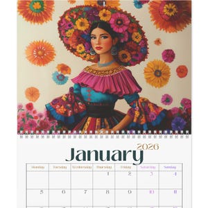 Puede incluir: Calendario de pared de 2026 con una vibrante ilustración de una mujer adornada con flores y vestimenta tradicional. La página del calendario muestra el mes de enero con una cuadrícula de fechas. La obra de arte está sobre un fondo crema.