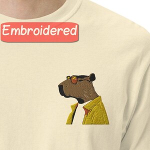 Hipster dier geborduurd shirt, stijlvolle cartoon capibara in gele jas, cool urban wildlife grafisch T-shirt, unisex mode-top