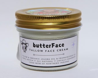 May include: A small glass jar of "butterFace" tallow face cream with a gold lid. The label includes the product name, ingredients, and the phrase "Chad Mom of Northern Indiana". The jar is filled with a white cream.