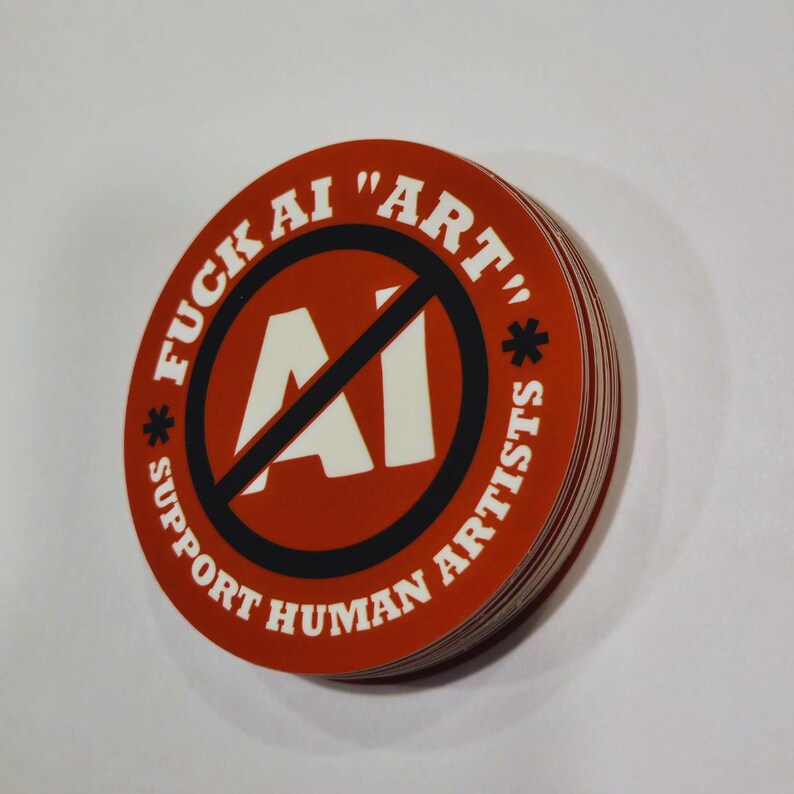 May include: A stack of round stickers with a red background and white text. The text reads "FUCK AI 'ART'" and "SUPPORT HUMAN ARTISTS". A black circle with a line through the letters "AI" is in the center.