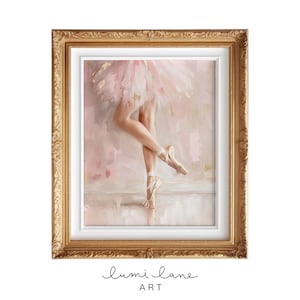 May include: A framed painting of a ballerina wearing a pink tutu and pointe shoes. The background is a soft pink and white with gold accents.
