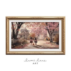 May include: Two young girls dressed as witches walk down a path lined with trees in autumn. They are carrying a jack-o-lantern and wearing pink dresses and black witch hats. The path is covered in fallen leaves and the trees are in shades of pink and orange.