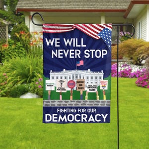 May include: A blue and white garden flag with the text "We Will Never Stop Fighting For Our Democracy". The flag features a white house with a red, white, and blue American flag on top. There are six people holding signs with various messages, including "Reproductive Freedom", "Affordable Healthcare", "End Racism Now", "Support Our Allies", "Save Our National Parks", and "Equality For All".