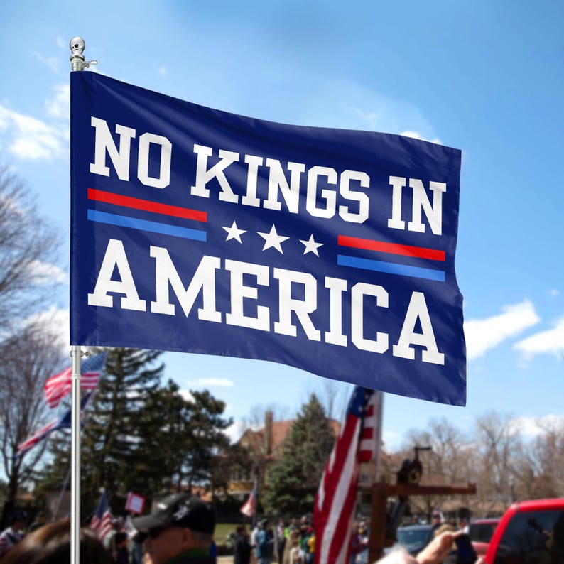 Puede incluir: Una bandera azul con texto blanco que dice "NO KINGS IN AMERICA". La bandera tiene tres estrellas blancas y rayas rojas y azules.