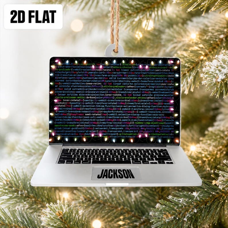 May include: A flat, 2D laptop-shaped Christmas ornament featuring a screen displaying lines of computer code surrounded by a border of colorful holiday lights. The silver-colored base includes a trackpad with the name JACKSON printed on it.