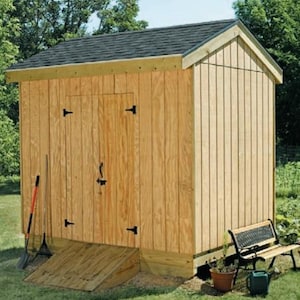 May include: A wooden shed with a brown shingled roof and a ramp leading to the double doors. The shed is painted a light brown colour and has black hinges on the doors.