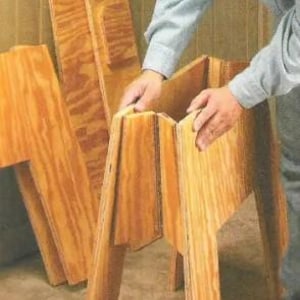 May include: A wooden stool made from plywood panels that can be folded flat for storage.