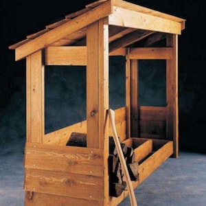 Puede incluir: Un estante de almacenamiento de leña de madera con techo inclinado. El estante está construido con madera de color claro y presenta múltiples compartimentos para almacenar leña. Un hacha se apoya en el lateral del estante, lista para usar.