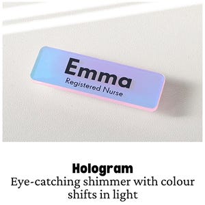 May include: A rectangular name badge with a holographic finish that shifts between blue and pink tones. The text Emma is printed in bold black letters, with the words Registered Nurse printed in smaller black letters underneath the name.