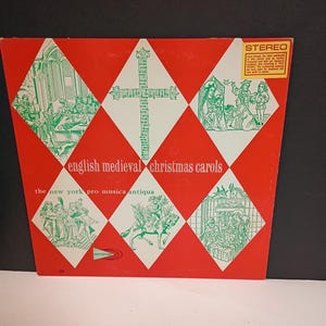May include: Vintage vinyl record album cover with a red background and white diamond shapes. The album is titled "English Medieval Christmas Carols" with illustrations in green. A "Stereo" sticker is in the upper right corner.