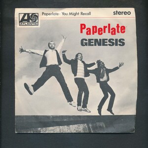 May include: Vintage album cover for the Genesis single "Paperlate." The cover features three men jumping in the air against a cloudy sky. The band's name is in large, bold letters, with the Atlantic Records logo in the upper left corner.