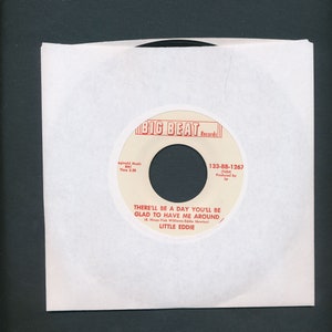 May include: A white vinyl record with a black label. The label has the text "BIG BEAT Records" in red letters. The record is titled "THERE'LL BE A DAY YOU'LL BE GLAD TO HAVE ME AROUND" by "LITTLE EDDIE". The record number is "133-BB-1267".